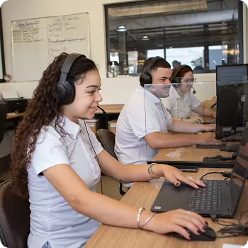Atendente sorridente usando headset em call center prestando suporte técnico
